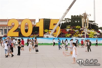 2015年
8月25日，天安门广场，游客们在天安门广场“长城”花坛前游玩。