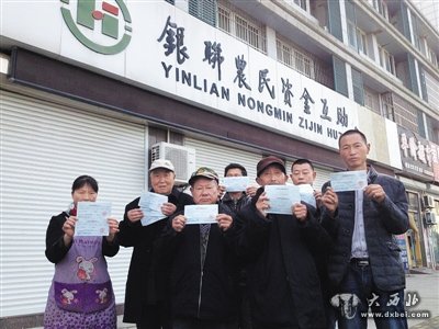 11月15日，江苏盐城市银联农民资金互助合作社门口，多位“储户”手持还未兑现的存款凭条。这家合作社将互助资金投资房产项目失败，导致资金链断裂倒闭。新京报记者 谷岳飞 摄